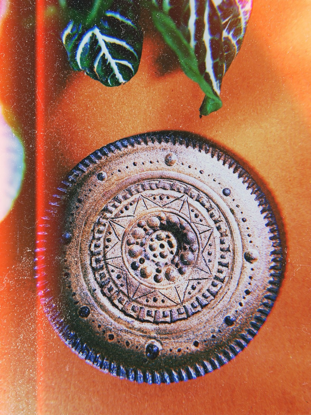 A hand-carved mandala dish in warm brown clay, photographed from above