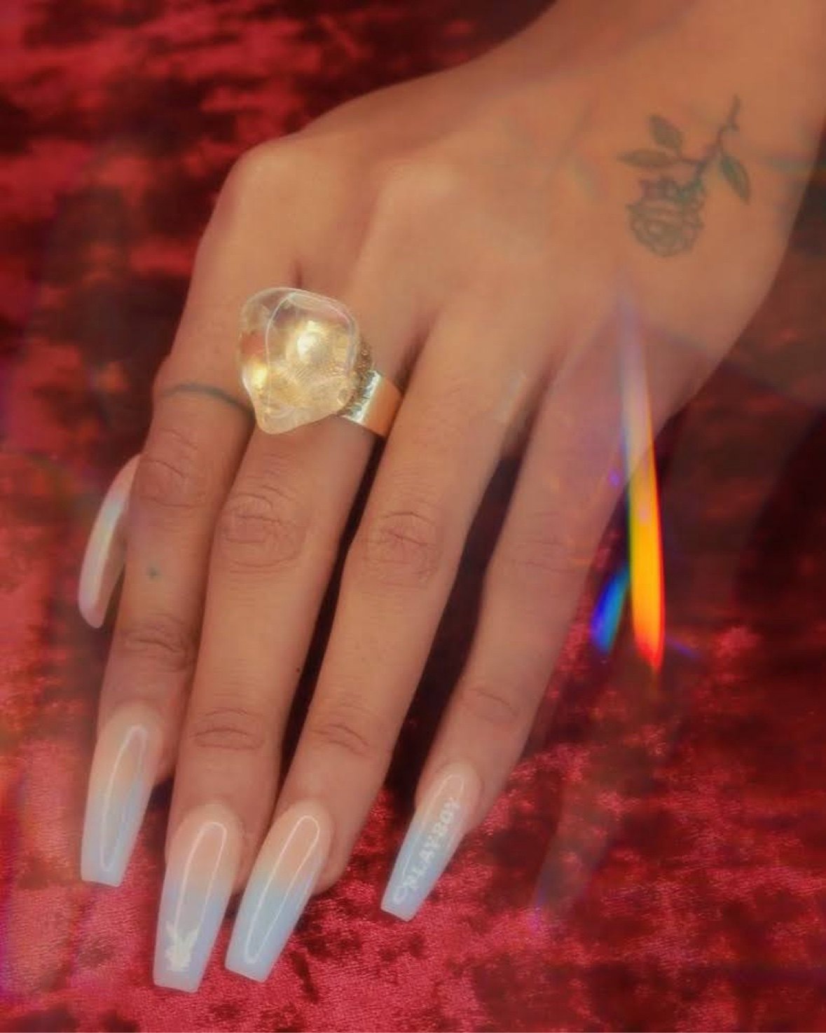 A hand wearing a sculpted raw-crystal statement ring