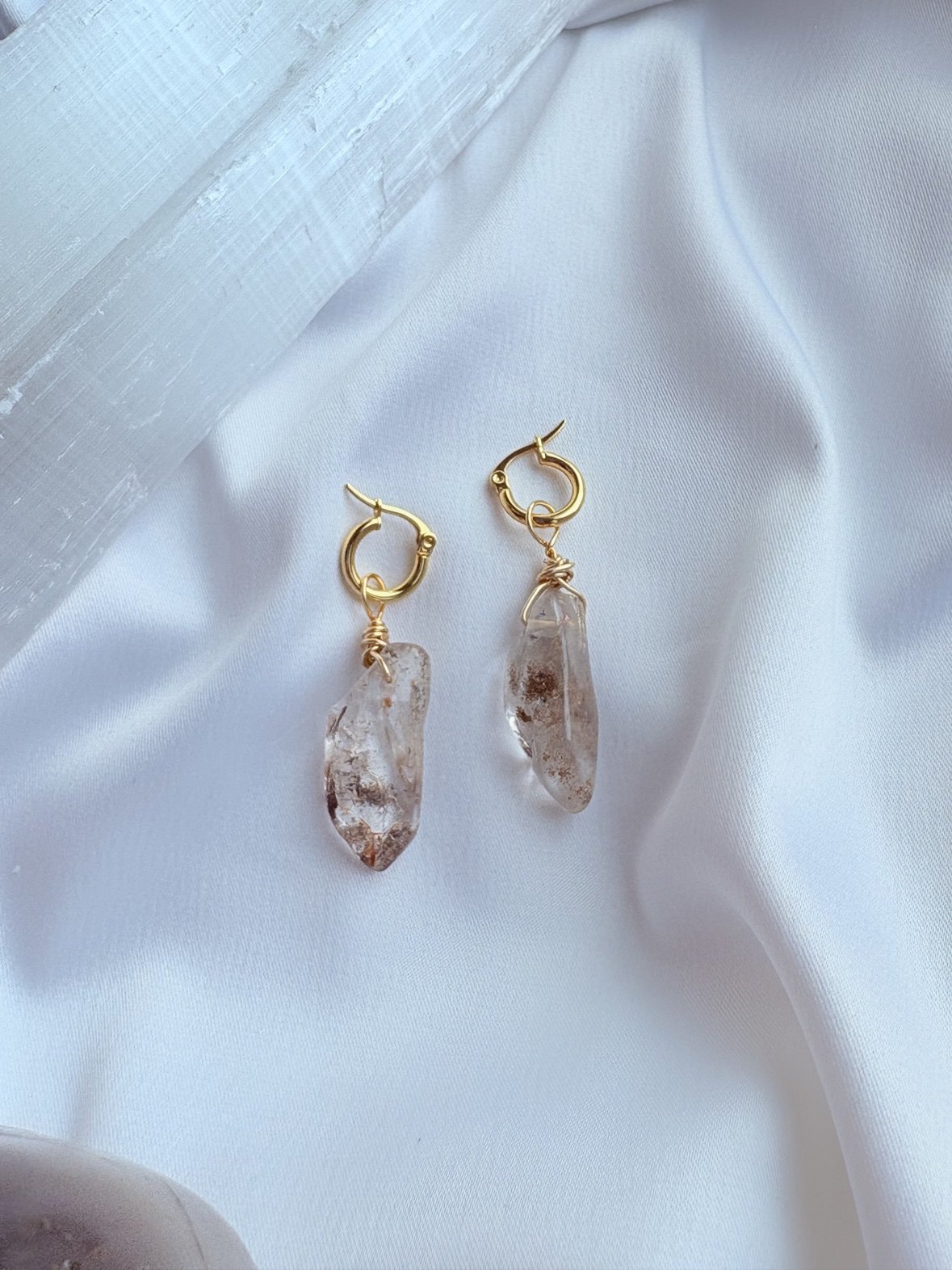 Gold huggie earrings with wire-wrapped raw crystal drops