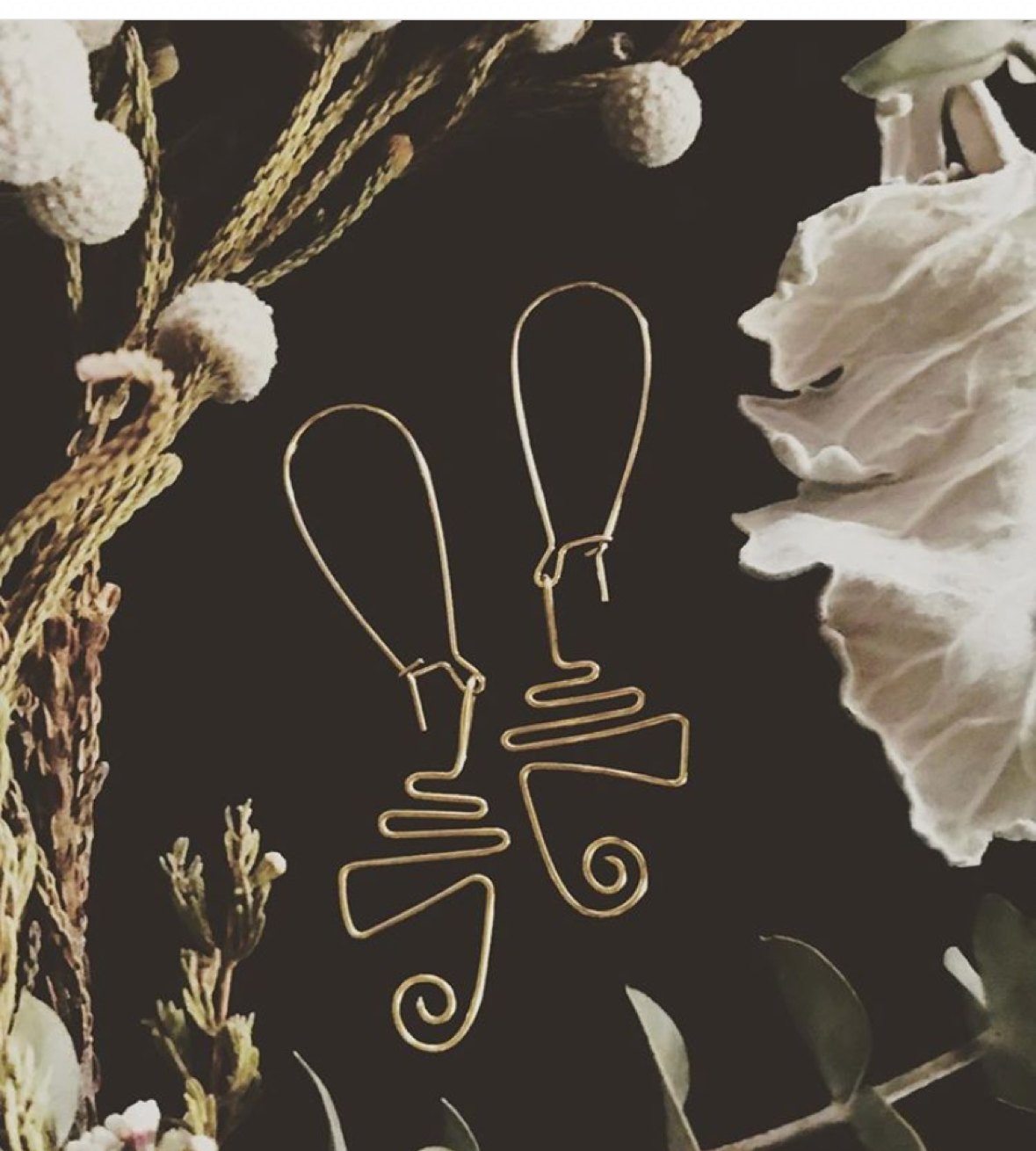 Gold wire 'Azizi' earrings among dried botanicals